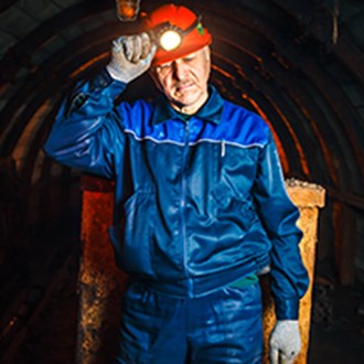 Een mijnwerker staat in een mijnschacht