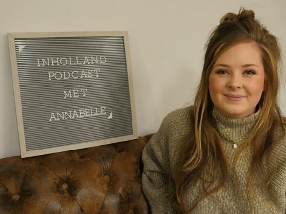 Annabelle zit naast een bord: "Inholland podcast met Annabelle"
